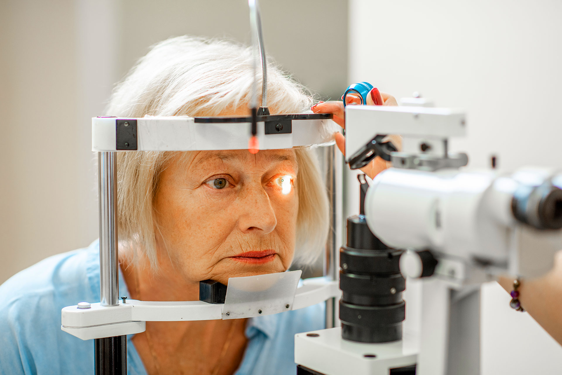 Senior woman having comprehensive eye exam with ophthalmic diagnostic equipment